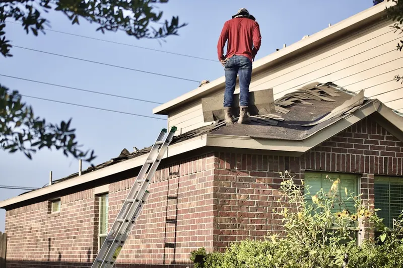 Professional roofer working on a residential roof in West Side